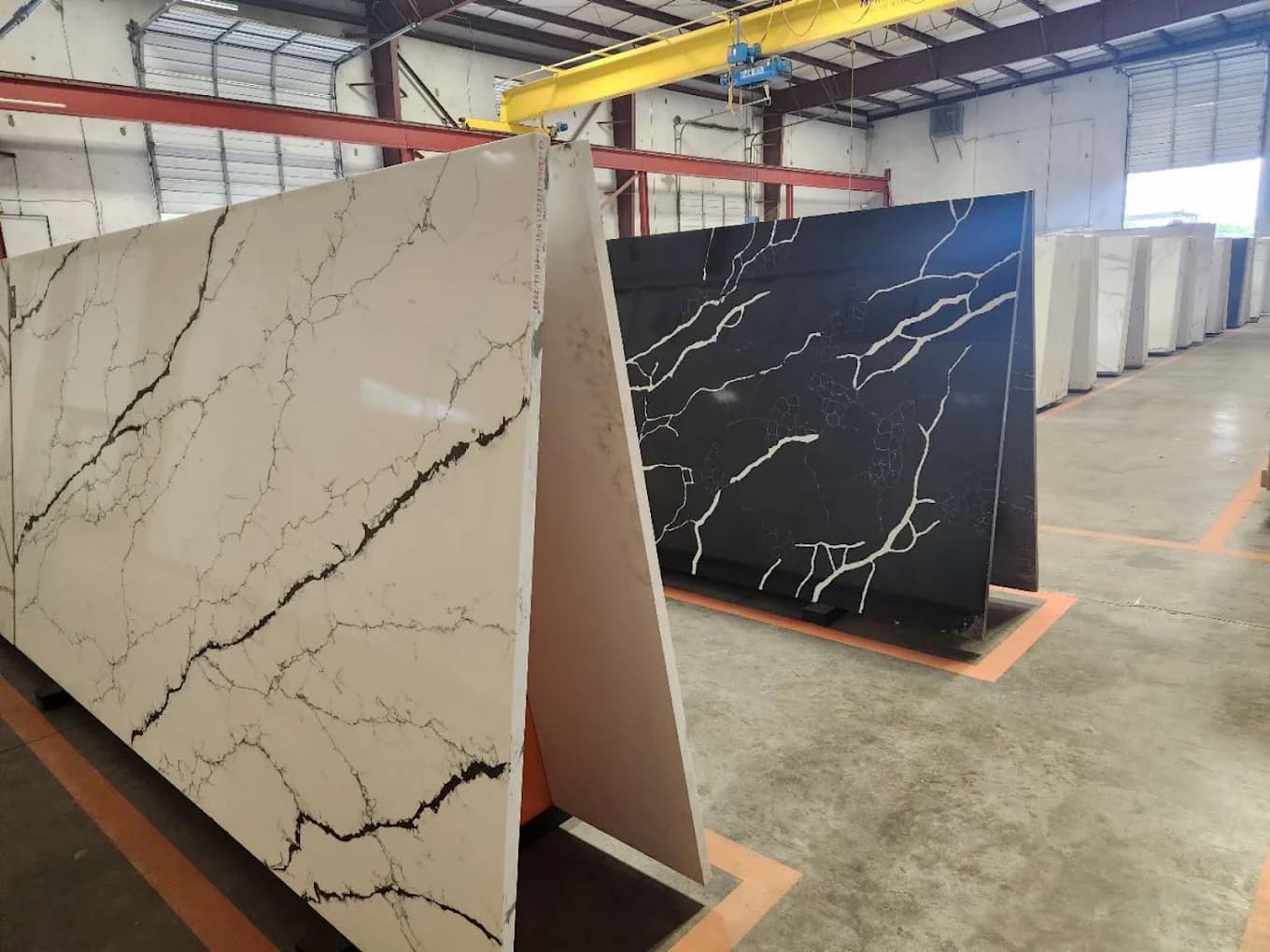 Quartz slabs staged on A-frames under the gantry crane inside H&E's Clay Rd fabrication warehouse in Houston